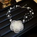 Detail view of multi-strand pearl necklace with a large white fabric flower - Flower