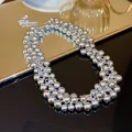 Detailed view of a multi-strand polished silver bead necklace resting on a mirror - Cluster Ball