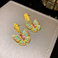 Macro shot of elegant butterfly earrings with multi-colored crystals and gold pleated finish - Butterfly (WE196) / Gold