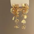 Detailed view of gold wrinkled floral dangle earrings with delicate metal petals. - Double Layer Petal Style / Gold