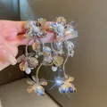 Macro view of elegant silver wrinkled metal flower earrings featuring pearl tassels - Mirror Pearl Tassel Style / Silver