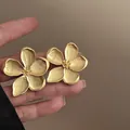Detailed macro view of matte gold flower stud earrings featuring elegant wrinkled petal texture - Matte Wrinkled Petal Style / Gold