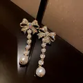 Elegant silver needle earrings with bow rhinestone design and dangling white pearls. - Bowknot Tassel Style (Silver Post)
