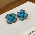 Detailed close-up of vintage flower-shaped stud earrings with turquoise-colored beads - Gun Black Jewelry / Lake Blue
