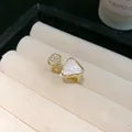 Nahaufnahme eines goldenen Rings mit einem Dreieck aus Perlmutt und Zirkonia-Pavé-Details - Gold