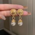 Detail view of French vintage gold plated earrings with elegant white pearl drops - Golden Round Pearl