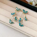 Elegant gold-tone butterfly tassel earrings with shimmering blue and clear crystals - Gold-Blue