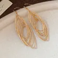 Detailed view of vintage gold multi-layered oval hollow drop earrings with zircons - Gold