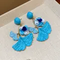 Macro view of bright blue raffia ginkgo leaf earrings with fabric flower details - Silver Post Gingko Leaf / Blue
