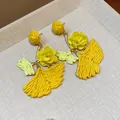 Close-up of yellow raffia ginkgo leaf earrings with delicate fabric rose accents. - Silver Post Gingko Leaf / Yellow