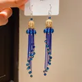 Close-up of retro royal style blue tassel earrings with elegant gold openwork. - Ear Hook Style (26#) / Blue