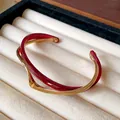 Detalle de una pulsera abierta de doble capa de acrílico burdeos y chapado en oro - Rojo Oscuro