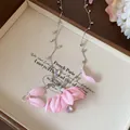 Close-up of elegant fabric flower necklace with iridescent teardrop charms - Pink