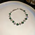 Primer plano de pulsera con circonitas verdes hexagonales y flores en plato - Estilo 69# Plateado Verde Cierre