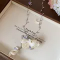 Detail view of a dainty necklace with fabric flower petals and rhinestone drops - Yellow