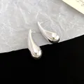 Close-up detail showing the glossy silver teardrop finish of these geometric stud earrings - Waterdrop Spiral Style / Silver