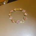 Detailed shot of an elegant pink gemstone and gold flower bracelet with sparkles - Bracelet-Pink