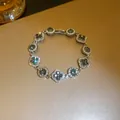 Close-up detail of an elegant flower and round crystal bracelet with dark stones and sparkle - Gray Bracelet