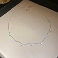 Collier élégant de couleur argentée avec sept breloques en zircone étincelantes sur chaîne - Blanc