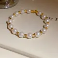 Macro view of elegant pearl beaded bracelet with sparkling rhinestones and gold spacers. - Gold