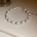 Detailed macro view of a vintage pearl bracelet featuring elegant sparkling rhinestone spacers - Silver