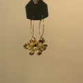 Detailansicht der goldenen Creolen mit strukturierten Blumenanhängern aus Metall. - Gold