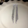 Elegant long silver rhinestone tassel drop earrings on white plate - Staircase Misaligned Slender Tassel Style (66#)