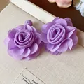 Close-up of elegant purple chiffon flower earrings with raffia accents on a textured surface. - Flower Stud Earrings / Purple