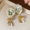 Close-up of elegant fabric flower earrings with gold leaf pendants and silver needles. - Flower Style (HE30866) / White