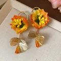 Detailed view of oversized orange fabric flower earrings with amber glass drops - Flower Style (HE30866) / Orange
