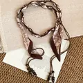 Détail d'une chaîne de taille bohème avec ruban paisley et glands en perles de bois - Paisley Beige Marron