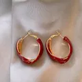 Primo piano dei dettagli degli orecchini a cerchio intrecciati in smalto rosso e oro - Stile Anello Intrecciato (10#)