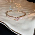 Detailed close-up of a golden zirconia open cuff bracelet featuring an intricate rose motif. - Style 8 / Gold