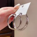 Primo piano dettagliato della trama spazzolata di questi eleganti orecchini a cerchio argento - Argento