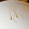 Close-up detail of elegant gold-toned long tassel ear lines with polished teardrop pendants - Geometric Water Drop (15#)