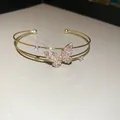 Elegant gold plated open bangle featuring a sparkling pink zircon butterfly centerpiece - Style 41 / Gold
