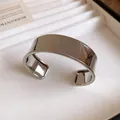 Close-up of polished stainless steel wide cuff bracelet with elegant curved surface - Mirror Polished Style / Silver