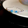 Elegant silver adjustable bangle with two sparkling blue heart-shaped zircons for women. - Style 51 / Silver-Blue