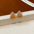 Primo piano dei dettagli degli orecchini a zucca retrò con zirconi gialli - Marrone