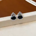 Primo piano di eleganti orecchini a zucca con pietre di zirconia cubica nere e chiare - Nero