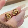 Close-up detail of retro Ancora red twisted knot stud earrings with gold trim - 3D Twist Knot (16#)