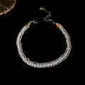Close-up of elegant double-row sparkling crystal bracelet with gold chain detail. - Wrapped Chain Bracelet / Silver