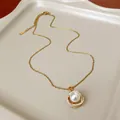 Dettaglio di un'elegante collana francese con perle e zirconi e pendente dorato chic. - Oro