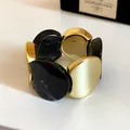 Vista dettagliata di un lussuoso bracciale elastico in acrilico giuntato oro e nero - Nero