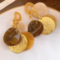 Vista dettagliata di orecchini boho retrò con resina e dischi in metallo dorato testurizzato - Stile Nappa a Disco / Caffè-Bianco