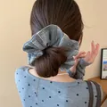 Rear view of a stylish woman wearing a grey plaid scrunchie with sparkling rhinestones - 43# Hair Tie - Gray With Rhinestone Plaid