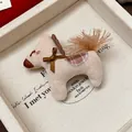 Gros plan d'une broche cheval tricotée avec un nœud marron dans sa boîte - Embroidered Horse Style / Blanc Cassé