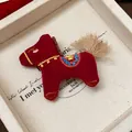Gros plan d'une broche cheval en tricot rouge avec des broderies et un pompon doux - Embroidered Horse Style / Bordeaux