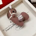 Gros plan d'une broche cheval tricotée marron présentée dans une boîte cadeau élégante. - Embroidered Horse Style / Café