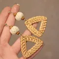 Vue macro détaillée de boucles d'oreilles pendantes en raphia tressé avec perles. - Style Triangle (1#)